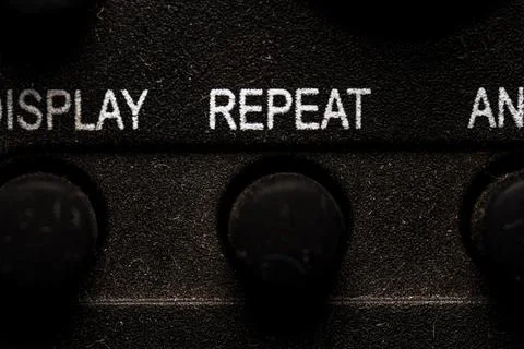 Tv repeat icon and button close up of a old dusty black Television remote c.. Stock Photos