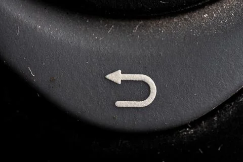 Tv return icon and button close up of a old black Television remote controlle Stock Photos