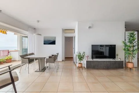 TV screen and empty dining table in comfortable apartment Stock Photos