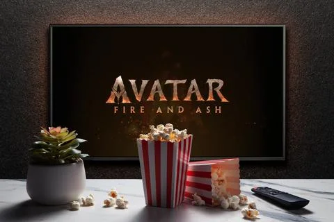 TV screen playing Avatar Fire And Ash trailer or movie. TV with remote contro Stock Photos