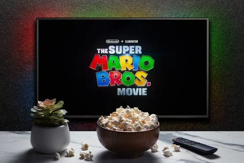 TV screen playing The Super Mario Bros. Movie trailer or movie. TV with remot Stock Photos