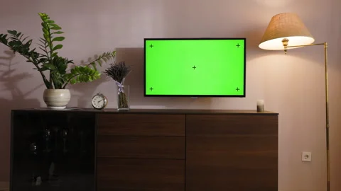 TV set with a green screen hangs on the wall in a stylish modern room. A Stock Footage 246847566