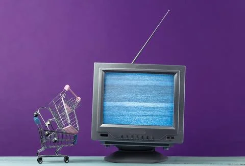 TV shop. Antenna old-fashioned retro tv with mini supermarket trolley on purp Stockfoto's