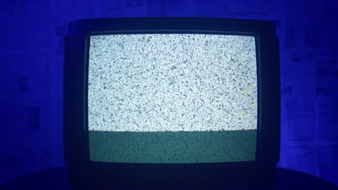 A TV with static noise stands in a dark blue room. Stock Footage 221623339