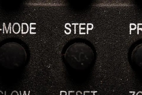 Tv step icon and button close up of a old dusty black Television remote con.. Stock Photos