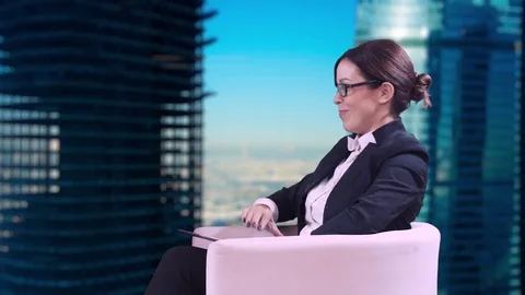 The TV Studio. Closeup of brunette in glasses. She sits in the Studio in a Stock-Footage 81563448