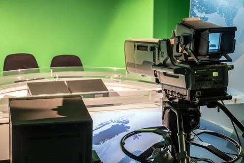 TV studio with professional camera aiming at empty seat, TV news studio Stock Photos