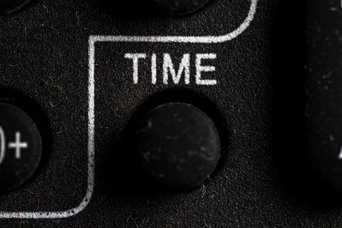 Tv time icon and button close up of a old dusty black Television remote con.. Stock Photos