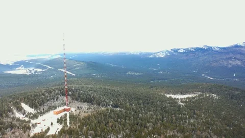 TV tower on the mountain among the winter pine forest Stock Footage 120400239