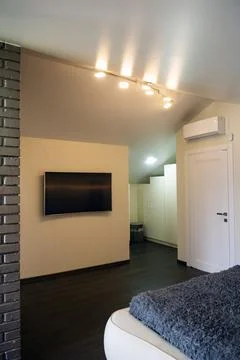 TV on the wall in the bedroom. Stock Photos