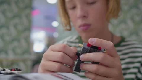Tween boy assembling building blocks in cafe Stock Footage 252735194