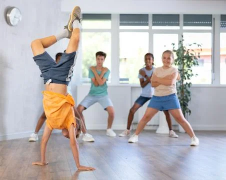 Tween boy breakdancer performing acrobatic elements in dance studio Stock Photos