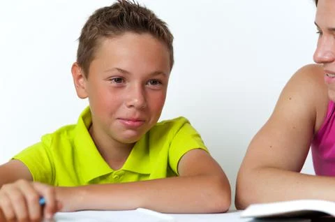 Tween boy doing homework with his mother. Stock Photos