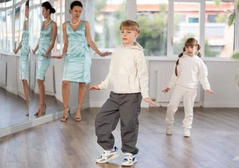 Tween boy mimicking comedic stroll of Charlie Chaplin during dance rehearsal Stock Photos