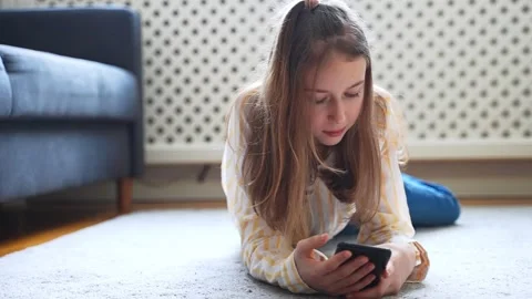 Tween girl with smartphone lying on the ... | Stock Video | Pond5