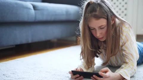 Tween girl with smartphone lying on the ... | Stock Video | Pond5