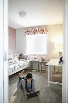 Tween girl using digital tablet on bedroom floor Stock Photos