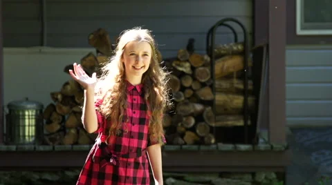 A tween girl waves in front of her home Stock Footage 44106428