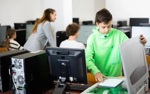 Tween schoolboy copying lecture note on copier in computer class Stock Photos