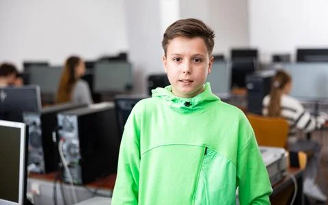 Tween schoolboy standing in computer class ready for lesson Stock Photos