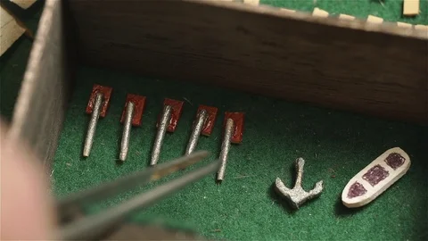 Tweezers Picking Up Tiny Parts of a Model Ship from Wooden Box, Close Up  Stock Footage 85822949