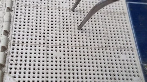 Tweezers touching processor pin holes, macro video Stock Footage 310464413