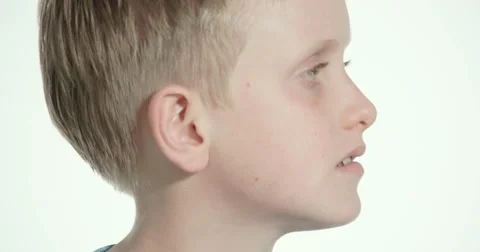 Twelve year old blond boy turns towards camera, smiles and nods in agreement Stock Footage 54414666