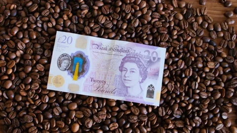 Twenty pound  on coffee beans in close-up Stock Footage 296492473