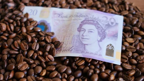 Twenty pound  on coffee beans in close-up Stock Footage 296522211