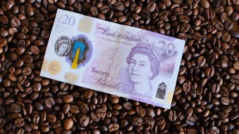 Twenty pound  on coffee beans in close-up Stock Footage 296600954