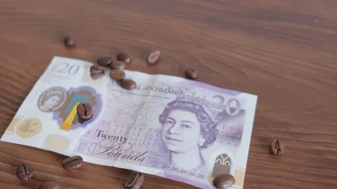 Twenty pound  on coffee beans in close-up Stock Footage 296639835