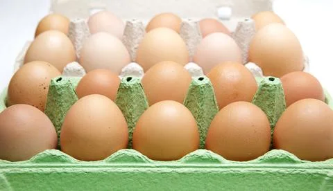 Twenty rustic brown eggs lie in cardboard boxes on a wooden white table Stock Photos