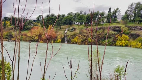Twigs framing flowing green river - photographer perspective Stock Footage 327478634