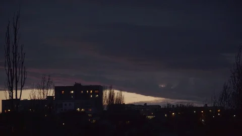 Twilight and dark clouds behind houses and trees at the edge of the town Stock Footage 107071286