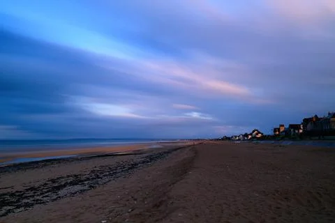 Twilight clouds over Sword Beach shoreline Stock Photos