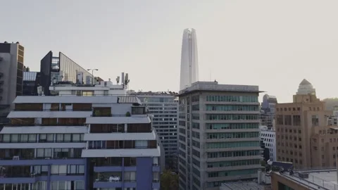 Twilight drone slide across Apoquindo rooftops toward Costanera Center Santiago 库存影片 334637052