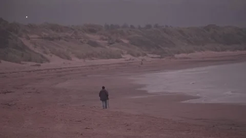As twilight falls, he strolls the shore, a quiet life to underscore Vídeos de archivo 319814832