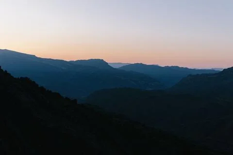 Twilight gradient sky over mountain silhouette range during dramatic dawn Stock Photos