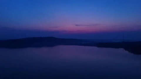 Twilight lake reflection with wind turbine silhouette Video stock 333808508