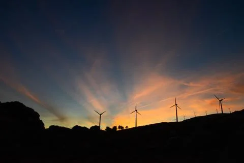 Twilight Rays at Sunset over a Wind Farm Stock Photos