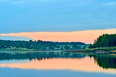 Twilight with reflection of the evening sky in water of the lake tightened by a Stock Photos