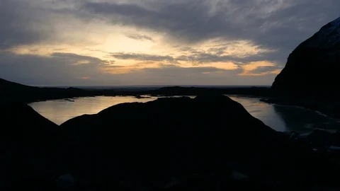 Twilight with reflection on a lake surrounded by silhouette mountains Stock Footage 93969305