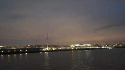 A twilight scene featuring a waterfront city illuminated by artificial lights Stock Footage 313475412