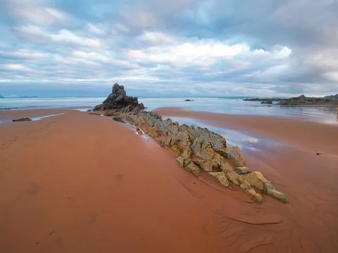 Twilight seascape with dramatic, cloudy skies - A tranquil scene of a rocky.. 스톡 사진