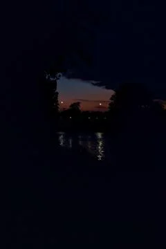 Twilight sky with clouds framed by trees Stock Photos