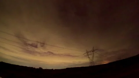 Twilight sky with shifting clouds and power lines Stockbeeldmateriaal 335305334
