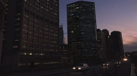 Twilight traffic in front of large office buildings Stock Footage 53044156