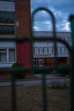 Twilight view of Soviet era school in Minsk through fence bars Stock Photos