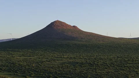 Twilight Volcanic Cone and Wind Turbines Pull Back 4K HLG Stock Footage 343800292
