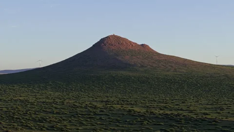 Twilight Volcanic Cone &amp; Wind Turbines Aerial Orbit Left 4K HLG Stock Footage 343800104